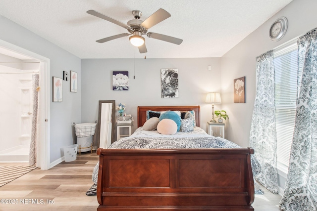 bedroom with light wood-style flooring, a ceiling fan, baseboards, and a textured ceiling