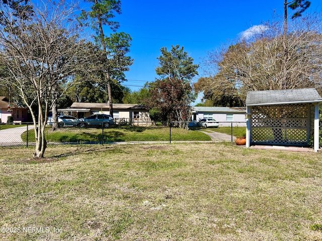 view of yard with a storage shed, an outdoor structure, and fence