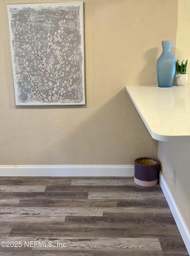 stairway featuring baseboards and wood finished floors