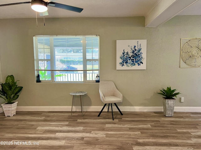 sitting room with ceiling fan, baseboards, and wood finished floors