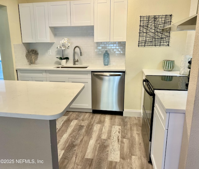 kitchen with stainless steel dishwasher, light countertops, electric stove, and a sink