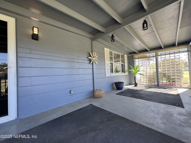 unfurnished sunroom with beam ceiling