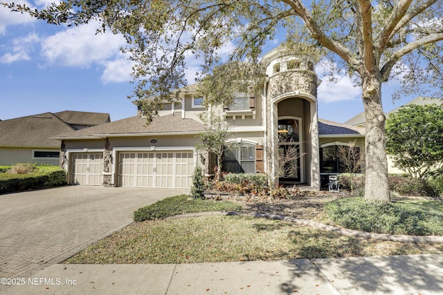 view of front of property with stucco siding, decorative driveway, and a garage