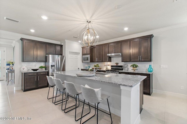 203 Country Brook Ave, Ponte Vedra, FL 32081 - kitchen with visible vents, under cabinet range hood, dark brown cabinetry, appliances with stainless steel finishes, and a sink