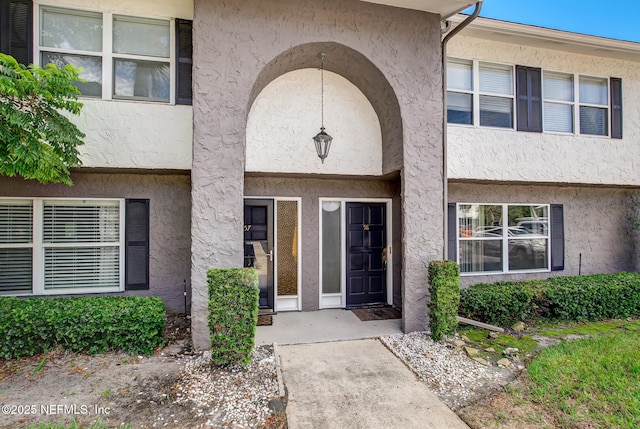 doorway to property featuring stucco siding