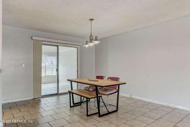 dining room with a chandelier, baseboards, a textured ceiling, and light tile patterned flooring