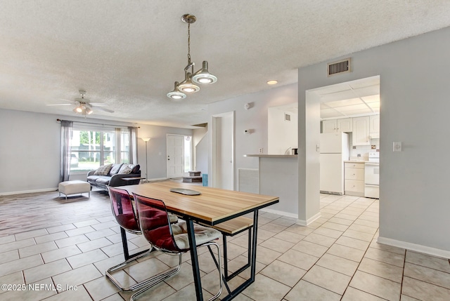 dining space with light tile patterned floors, baseboards, visible vents, and ceiling fan