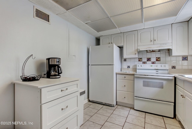 kitchen with decorative backsplash, white appliances, visible vents, and under cabinet range hood