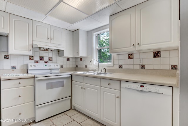 kitchen with backsplash, under cabinet range hood, white appliances, white cabinetry, and a sink