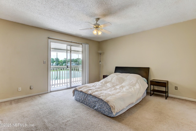 carpeted bedroom featuring access to outside, a ceiling fan, baseboards, and a textured ceiling