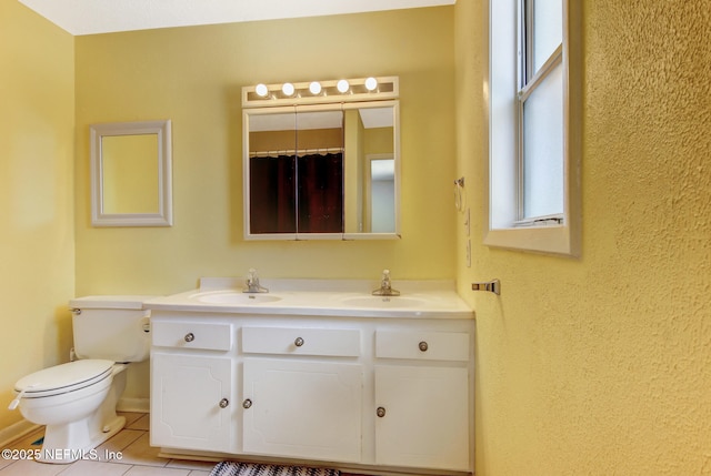 full bathroom featuring a sink, toilet, double vanity, and tile patterned floors