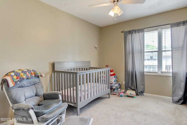 carpeted bedroom featuring multiple windows, a ceiling fan, baseboards, and a textured ceiling