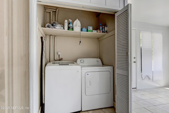 washroom featuring independent washer and dryer, light tile patterned flooring, and laundry area