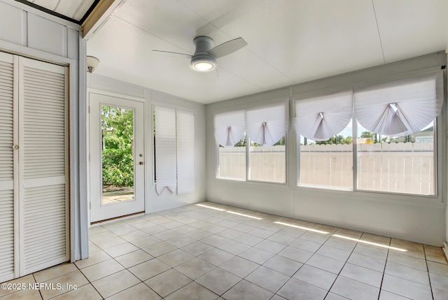 unfurnished sunroom featuring a ceiling fan