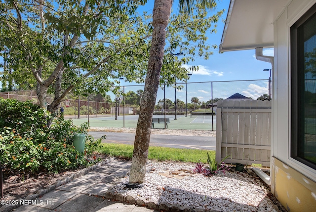 view of yard featuring a tennis court and fence