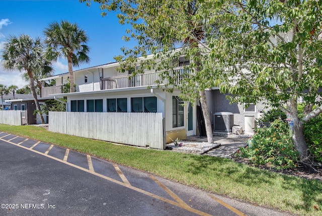 exterior space with fence, central AC, and stucco siding