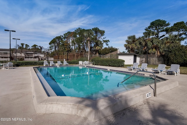 community pool with a patio and fence