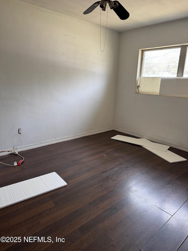 empty room with baseboards, a ceiling fan, and hardwood / wood-style flooring