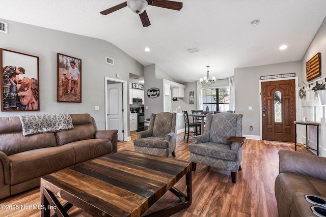 living area featuring visible vents, light wood-style flooring, baseboards, and vaulted ceiling