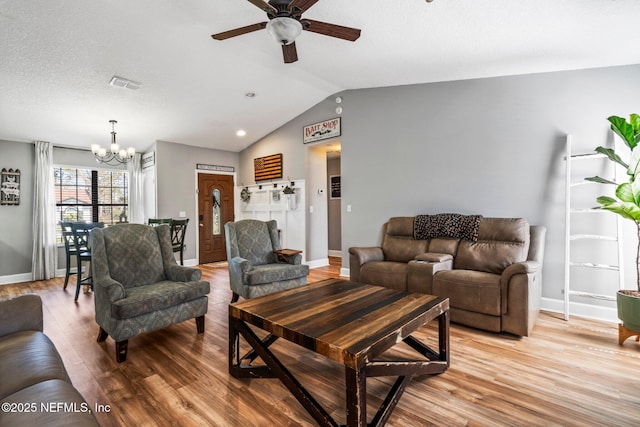 living area featuring vaulted ceiling, baseboards, visible vents, and light wood finished floors