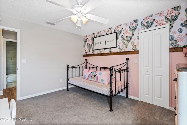 carpeted bedroom featuring visible vents, a textured ceiling, a closet, and wallpapered walls