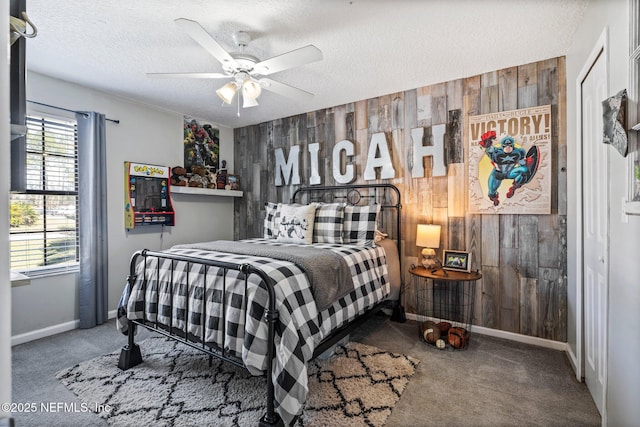 carpeted bedroom featuring a textured ceiling, wood walls, and an accent wall