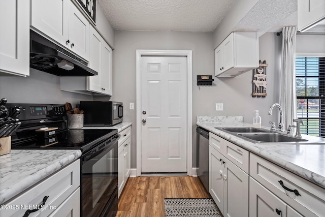 kitchen featuring under cabinet range hood, white cabinets, stainless steel appliances, and a sink