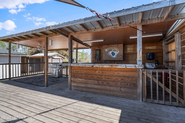 wooden deck featuring grilling area, an exterior structure, and an outdoor structure