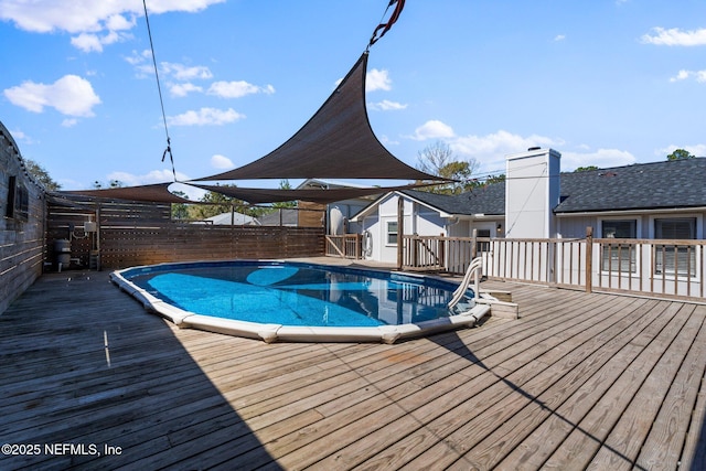 view of swimming pool with a fenced in pool, a wooden deck, and a fenced backyard