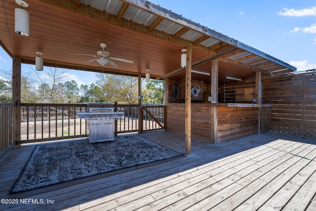 wooden terrace with an exterior structure, an outdoor structure, and a ceiling fan