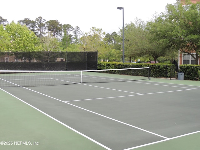 view of tennis court featuring fence