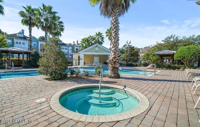 community pool featuring a gazebo, a patio area, and a hot tub