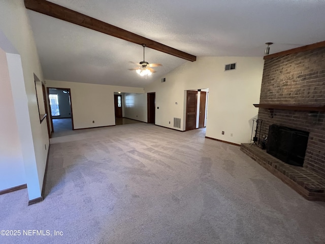 unfurnished living room featuring beamed ceiling, visible vents, carpet floors, ceiling fan, and a brick fireplace