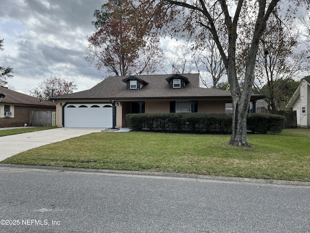 view of front of house with concrete driveway, an attached garage, a front lawn, and a shingled roof