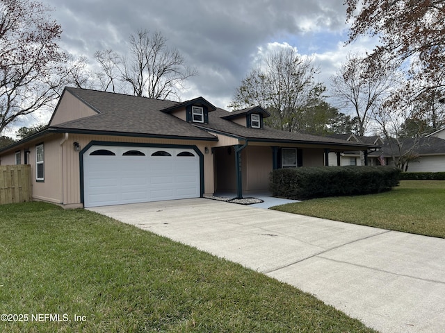 view of front of property featuring a front yard, fence, driveway, roof with shingles, and an attached garage