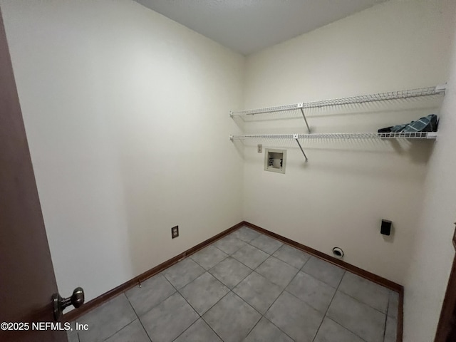 laundry area with laundry area, hookup for a washing machine, baseboards, and hookup for an electric dryer