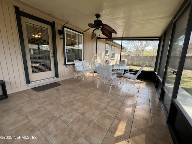 unfurnished sunroom with a ceiling fan