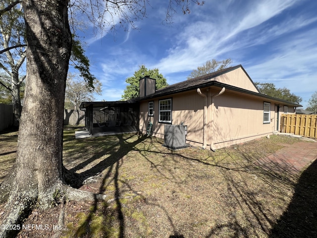 rear view of house featuring a patio area, a chimney, and fence