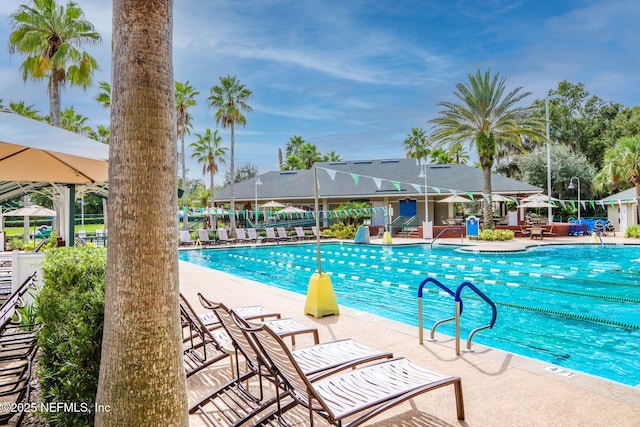 community pool with a patio area and fence