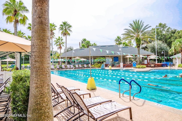 community pool with a patio and fence