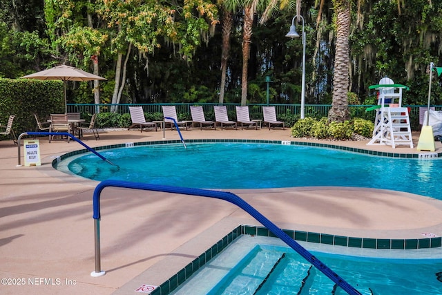 community pool featuring a patio area and fence