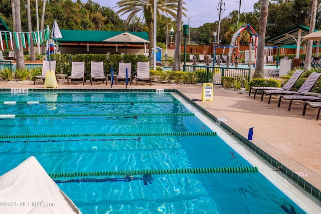 community pool featuring a patio area and fence