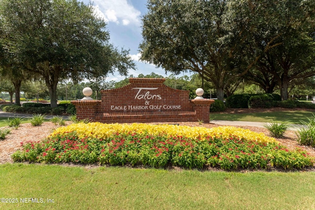 community / neighborhood sign featuring a lawn