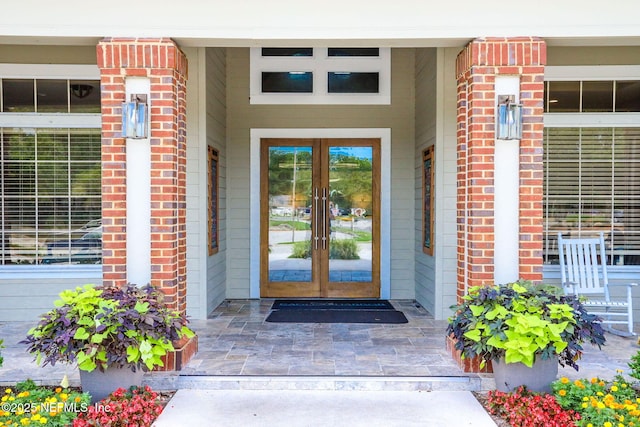 property entrance featuring french doors and brick siding