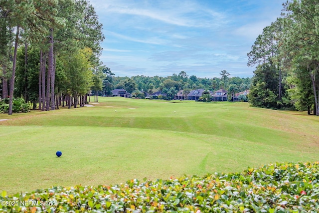 view of home's community featuring a lawn and view of golf course