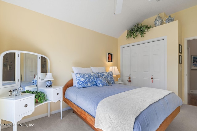 bedroom with lofted ceiling, light colored carpet, a closet, and baseboards