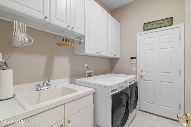 laundry room with a sink, cabinet space, light tile patterned floors, and washing machine and clothes dryer