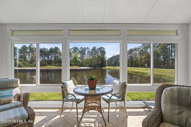 sunroom featuring a water view