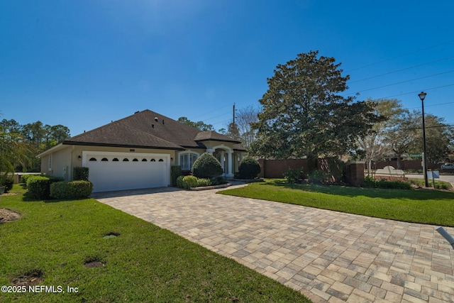 view of front of home featuring stucco siding, driveway, fence, a front yard, and an attached garage