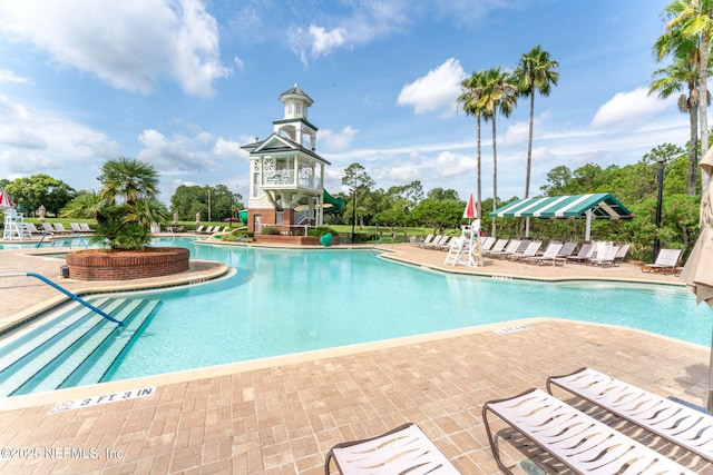 pool featuring a water slide and a patio area